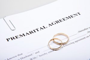 prenuptial agreement form with two gold wedding rings